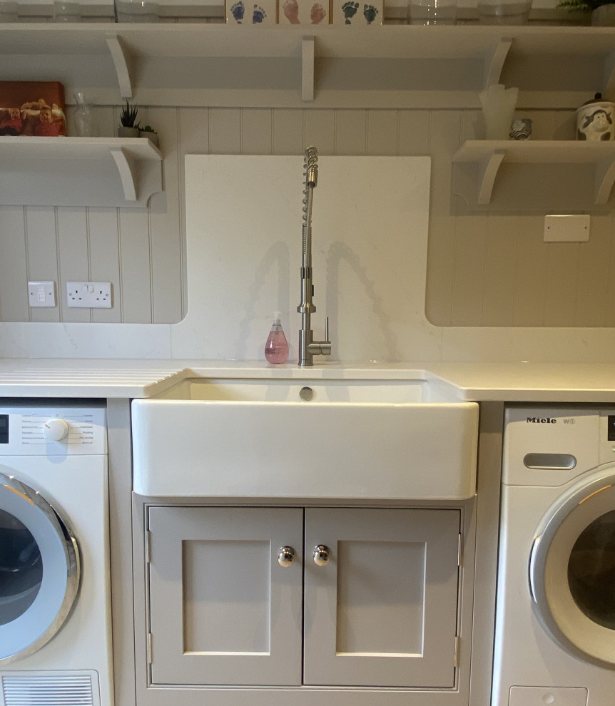 Inspiration for an expansive arts and crafts galley utility room in Sussex with a double-bowl sink, shaker cabinets, beige cabinets, white splashback, shiplap splashback, linoleum floors, brown floor and white benchtop.