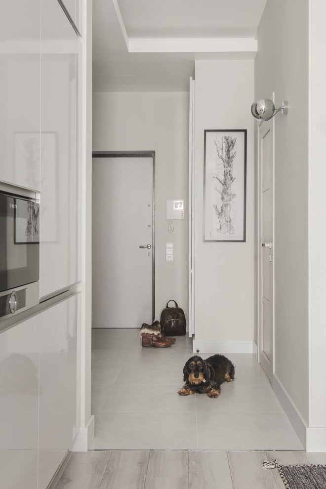 This is an example of a mid-sized contemporary front door in Moscow with porcelain floors, a single front door, a white front door, white floor, grey walls and recessed.