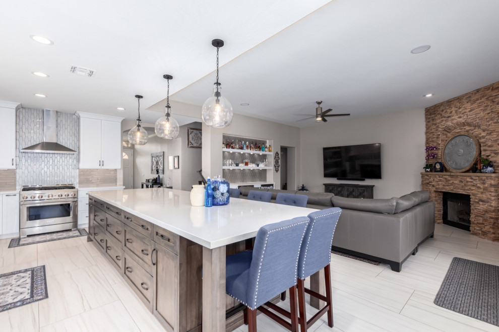 Example of a transitional kitchen design in Phoenix with a farmhouse sink, shaker cabinets, white cabinets, gray backsplash, stainless steel appliances and white countertops