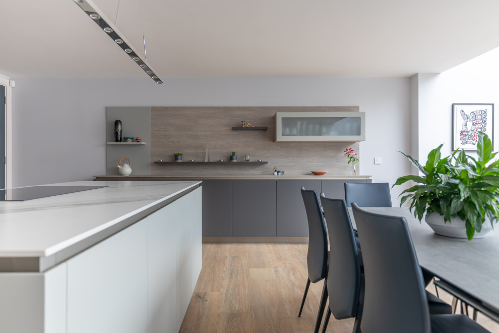Large contemporary kitchen in Sussex with composite countertops and an island.