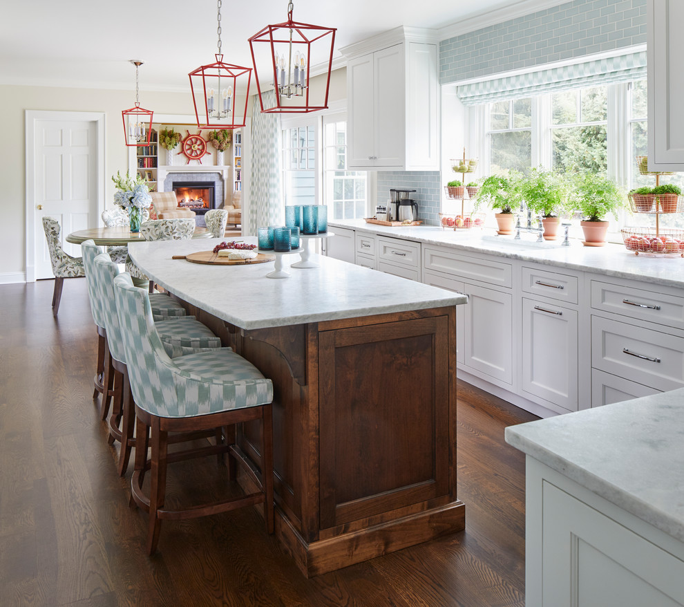 Example of a transitional u-shaped brown floor and dark wood floor eat-in kitchen design in Chicago with a double-bowl sink, white cabinets, quartzite countertops, blue backsplash, ceramic backsplash, an island, white countertops, shaker cabinets and stainless steel appliances