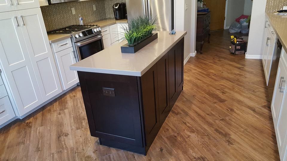 Kitchen - transitional medium tone wood floor kitchen idea in Phoenix with white cabinets, quartzite countertops, beige backsplash, stainless steel appliances and an island