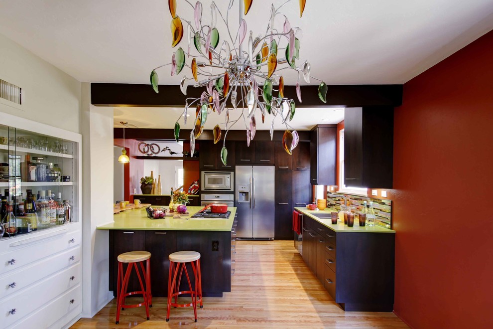 Photo of an eclectic l-shaped kitchen in San Diego with a double-bowl sink, flat-panel cabinets, dark wood cabinets, multi-coloured splashback, stainless steel appliances and green benchtop.