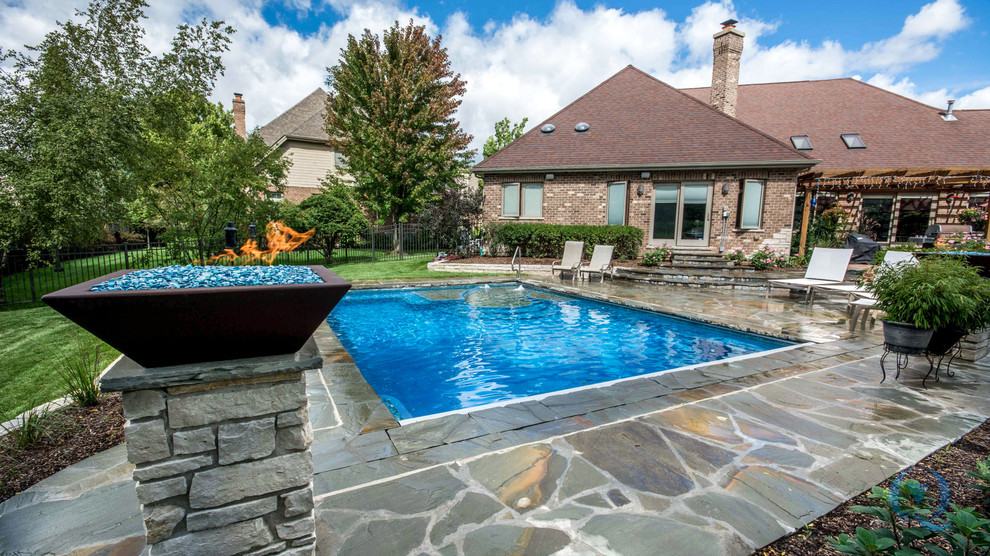 Pool fountain - mid-sized rustic backyard stone and rectangular lap pool fountain idea in Chicago