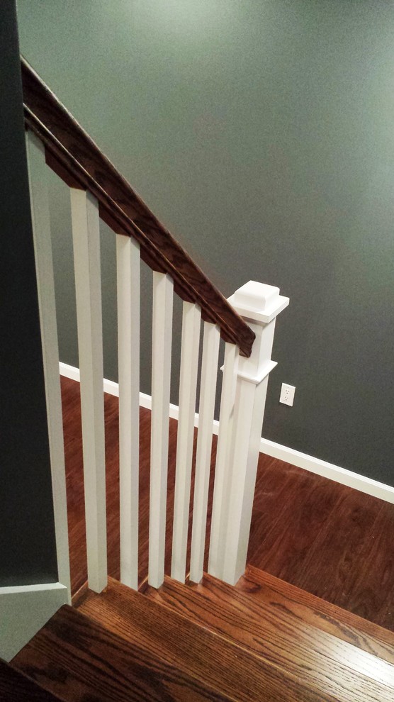 Inspiration for a mid-sized transitional wooden and underground vinyl floor and brown floor basement remodel with wooden risers and gray walls