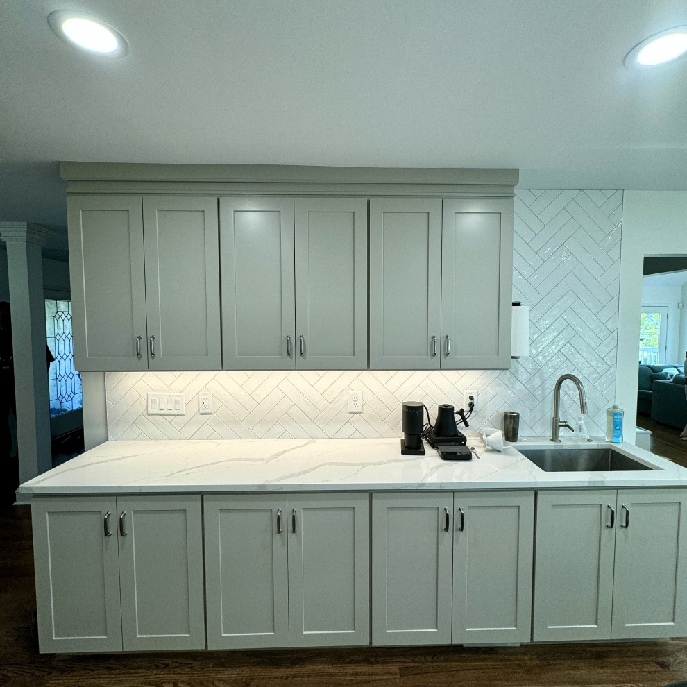 Mid-sized transitional u-shaped medium tone wood floor and brown floor open concept kitchen photo in Atlanta with an undermount sink, shaker cabinets, beige cabinets, granite countertops, white backsplash, stainless steel appliances, an island and white countertops