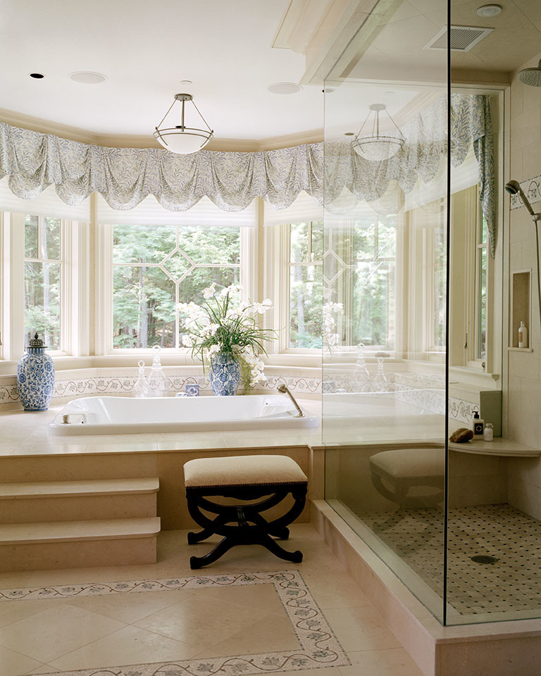 Design ideas for an expansive country master bathroom in Boston with furniture-like cabinets, medium wood cabinets, a drop-in tub, a corner shower, beige walls, travertine floors, an undermount sink and onyx benchtops.