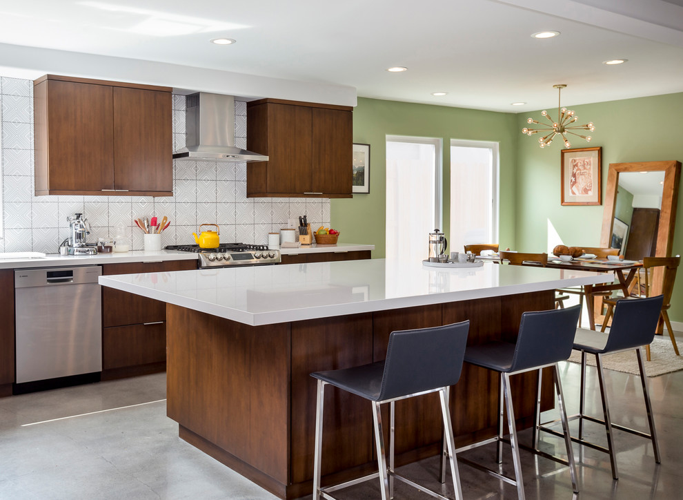 Design ideas for a large midcentury single-wall open plan kitchen in Los Angeles with an undermount sink, flat-panel cabinets, dark wood cabinets, quartz benchtops, white splashback, ceramic splashback, stainless steel appliances, concrete floors, with island and grey floor.