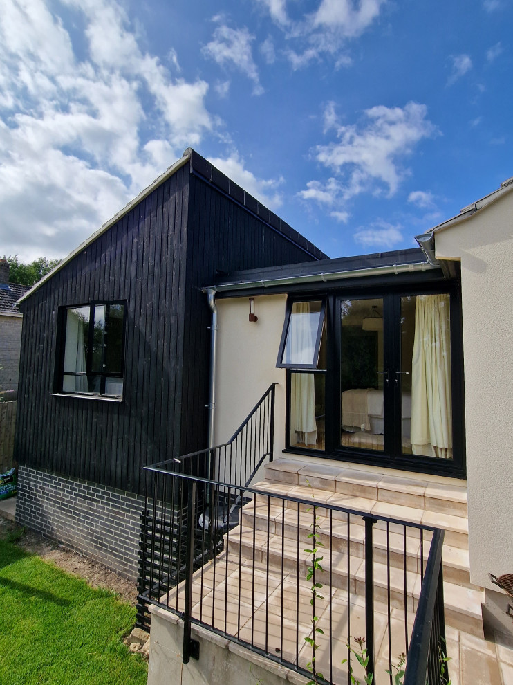 Photo of a large contemporary bungalow house exterior in Wiltshire with mixed cladding.