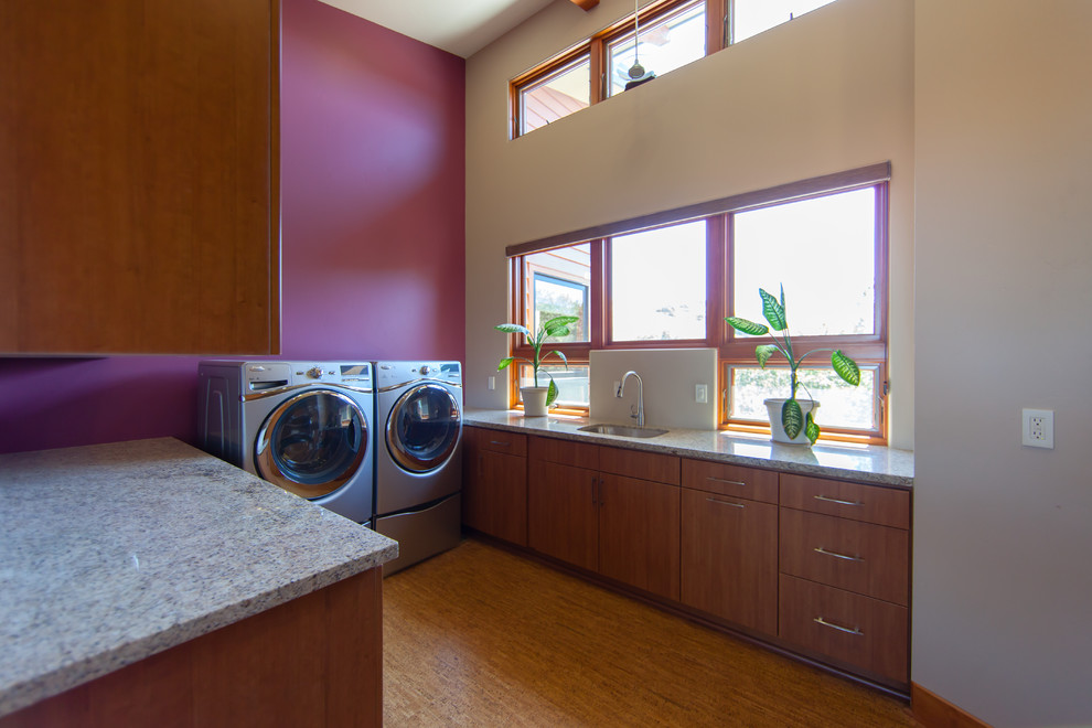 Photo of a large contemporary u-shaped utility room in San Luis Obispo with an undermount sink, flat-panel cabinets, medium wood cabinets, granite benchtops, cork floors, a side-by-side washer and dryer and pink walls.