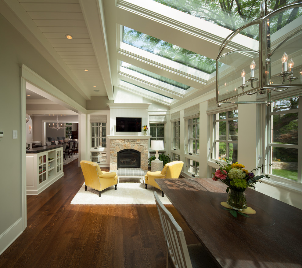 Inspiration for a large transitional sunroom in Minneapolis with medium hardwood floors, a stone fireplace surround, a skylight, a standard fireplace and brown floor.