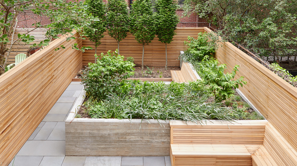 Small modern backyard garden in New York with natural stone pavers.