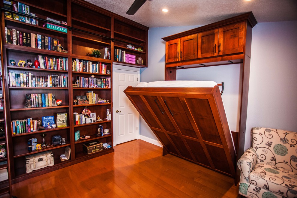 Photo of a mid-sized traditional home office in Orlando with a library, blue walls, medium hardwood floors, no fireplace, a built-in desk and brown floor.