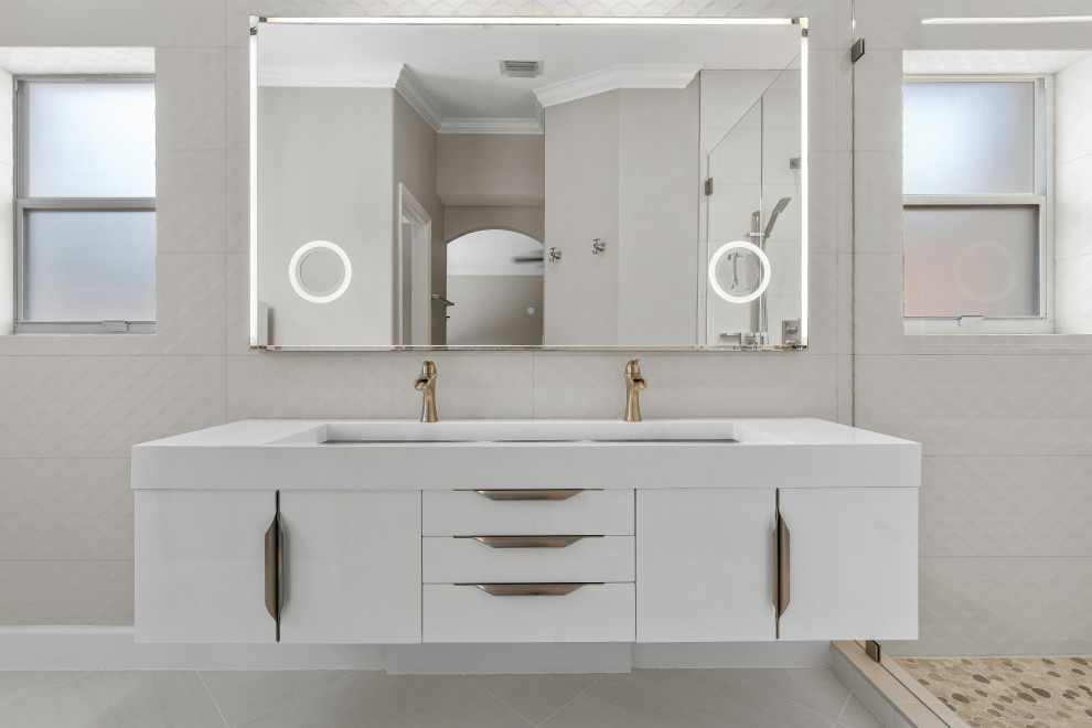 Design ideas for a mid-sized modern master bathroom in Miami with flat-panel cabinets, white cabinets, an open shower, a one-piece toilet, beige tile, porcelain tile, grey walls, porcelain floors, a trough sink, quartzite benchtops, grey floor, a hinged shower door, white benchtops, a niche, a single vanity and a floating vanity.