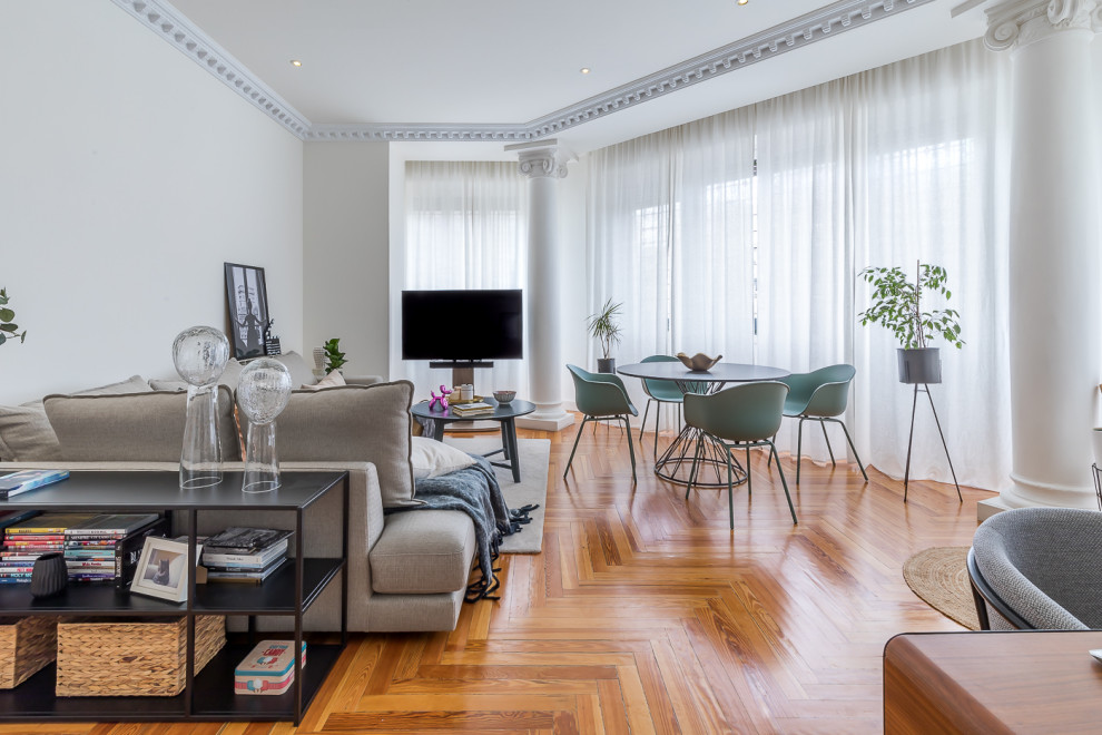 Photo of a mid-sized modern enclosed living room in Madrid with white walls, medium hardwood floors, a freestanding tv, brown floor and coffered.