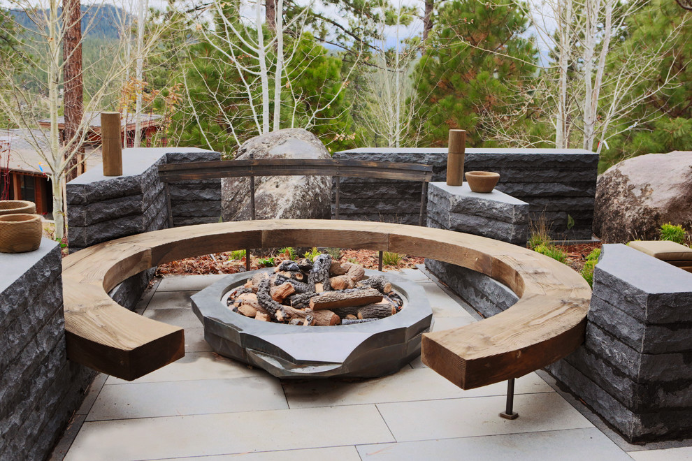 This is an example of an expansive contemporary patio in San Francisco with a fire feature, natural stone pavers and no cover.