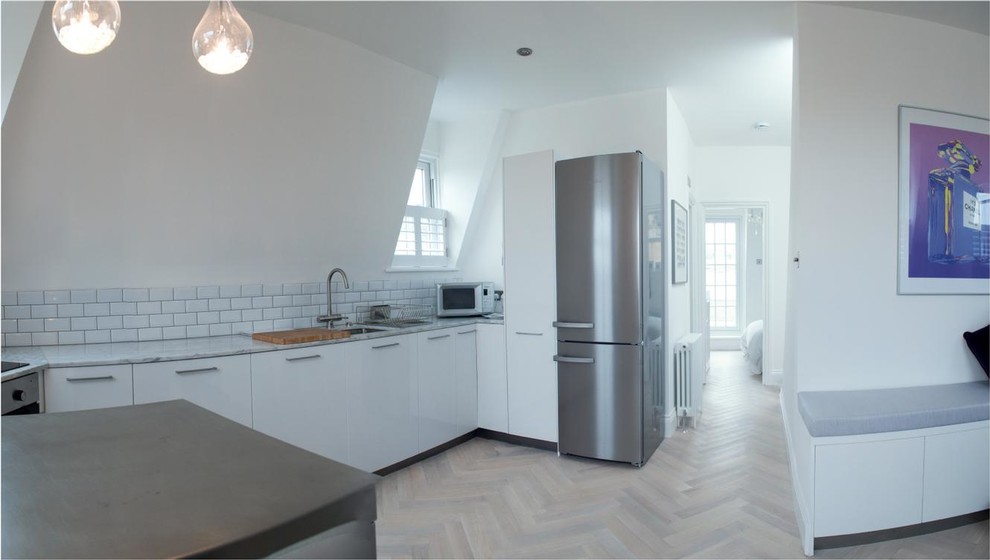 Photo of a small contemporary kitchen in London with light hardwood floors.