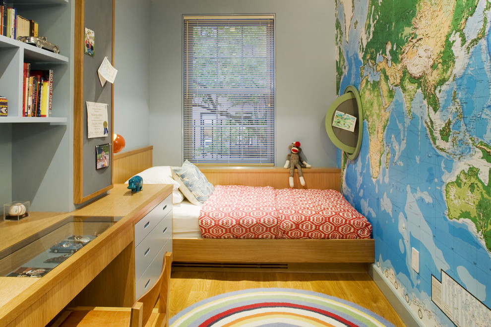 This is an example of a contemporary kids' room for boys in New York with grey walls and light hardwood floors.