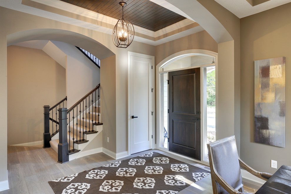 Design ideas for a large transitional foyer in Minneapolis with beige walls, light hardwood floors, a single front door and a dark wood front door.