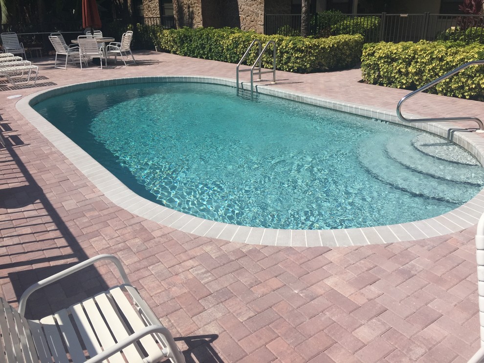 Design ideas for a mid-sized mediterranean backyard round lap pool in Tampa with brick pavers.