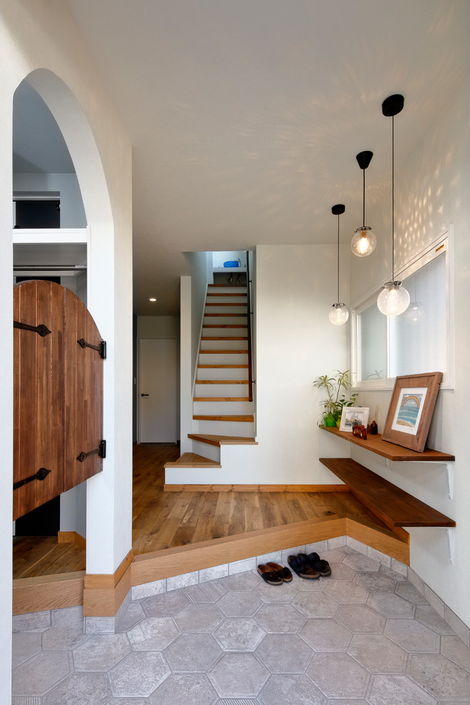 This is an example of a scandinavian entryway in Other with white walls, a single front door and grey floor.