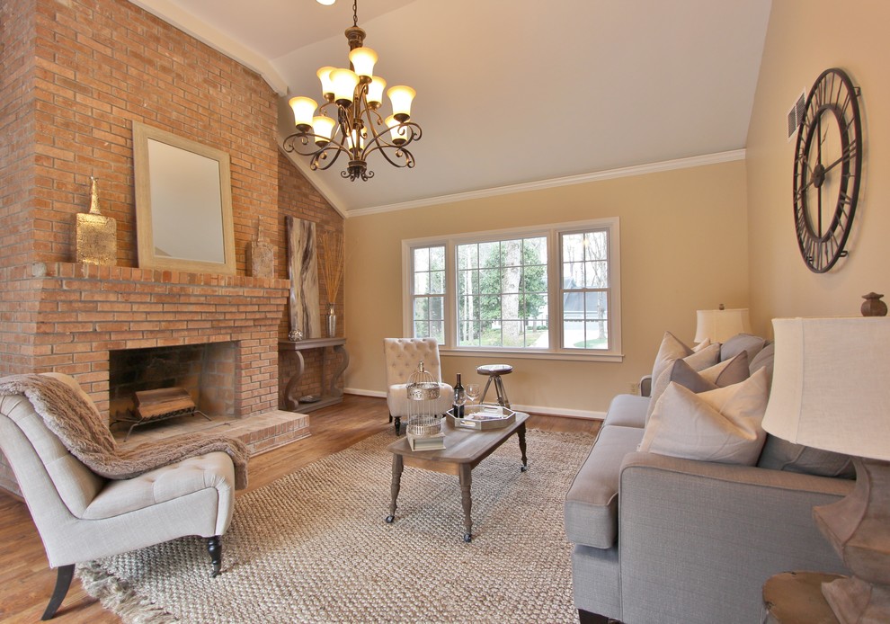 Photo of a transitional living room in Atlanta with yellow walls, medium hardwood floors, a standard fireplace and no tv.