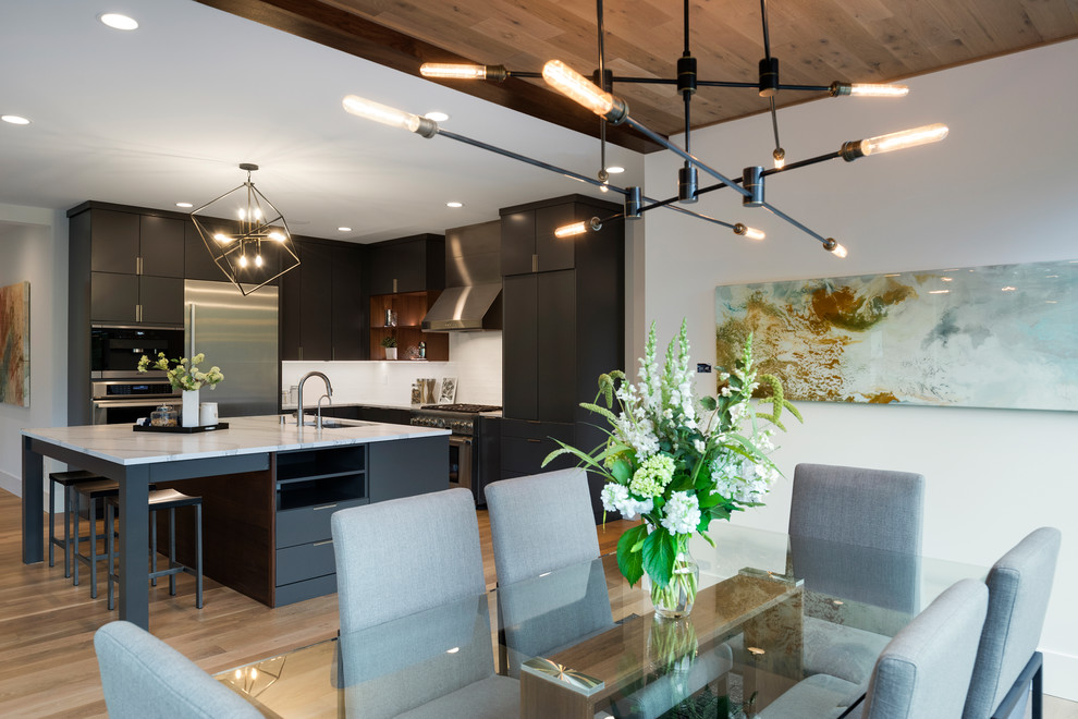 This is an example of a large modern kitchen/dining combo in Minneapolis with white walls and light hardwood floors.