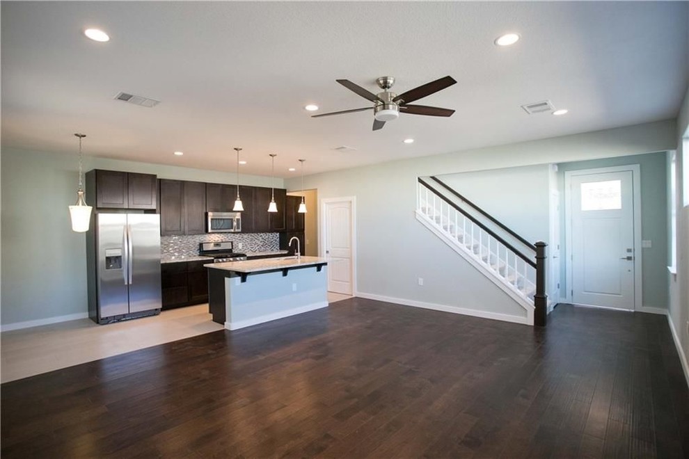 Example of a mid-sized transitional single-wall porcelain tile and beige floor eat-in kitchen design in Austin with a double-bowl sink, shaker cabinets, dark wood cabinets, granite countertops, gray backsplash, mosaic tile backsplash, stainless steel appliances, an island and gray countertops