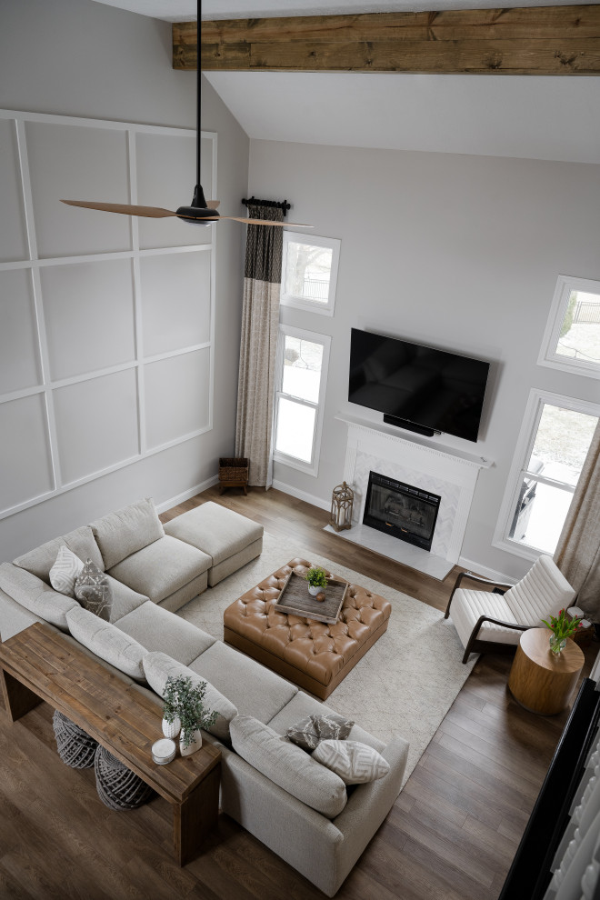 Example of a mid-sized danish formal and loft-style medium tone wood floor living room design in Indianapolis with white walls, a standard fireplace, a concrete fireplace and a wall-mounted tv