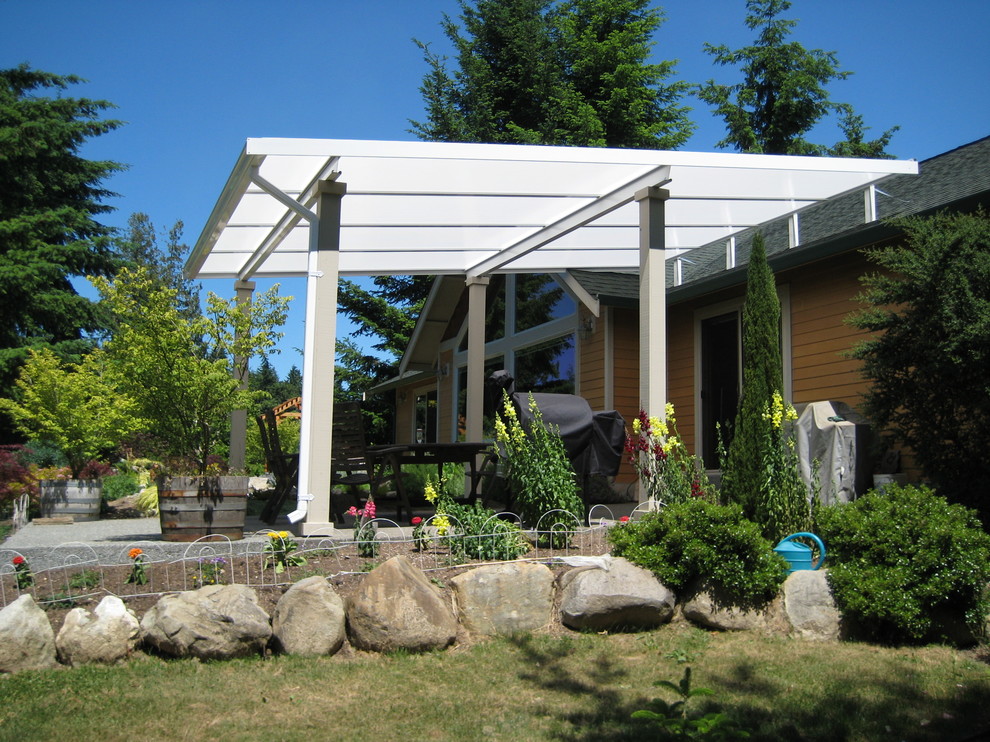 Mid-sized country backyard patio in Seattle with concrete slab and an awning.