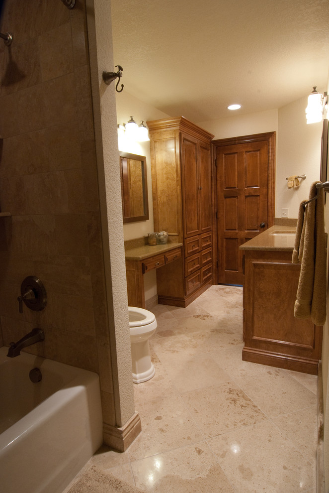 Mid-sized transitional master bathroom in Milwaukee with recessed-panel cabinets, brown cabinets, an undermount tub, a shower/bathtub combo, a one-piece toilet, brown tile, beige walls, travertine floors, an undermount sink, granite benchtops, brown floor and a shower curtain.