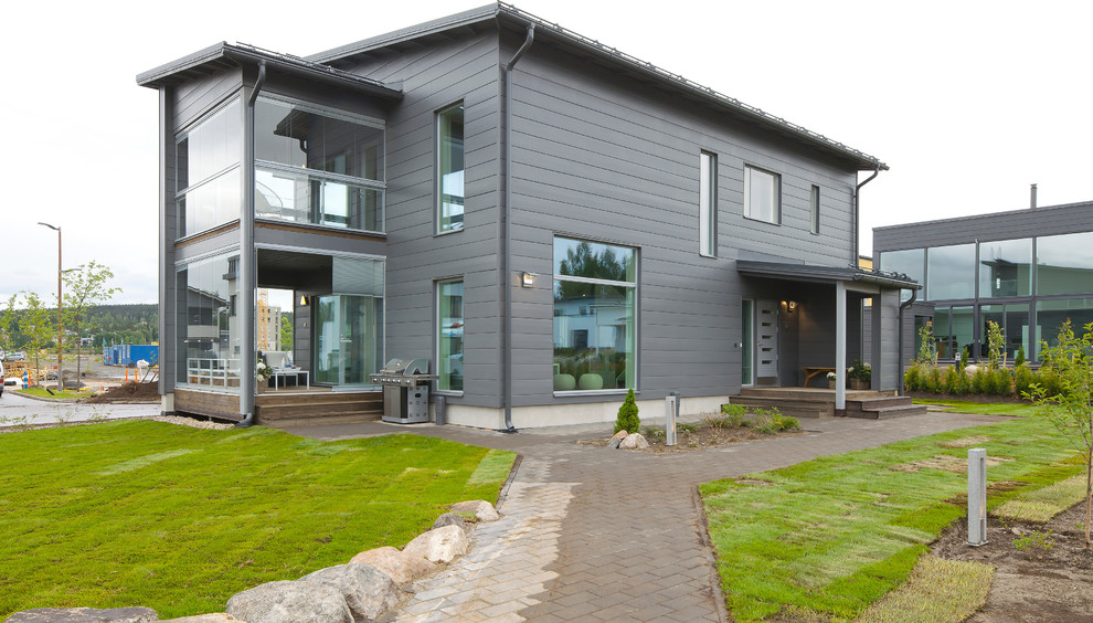 This is an example of a contemporary two-storey grey exterior in Devon with a shed roof.