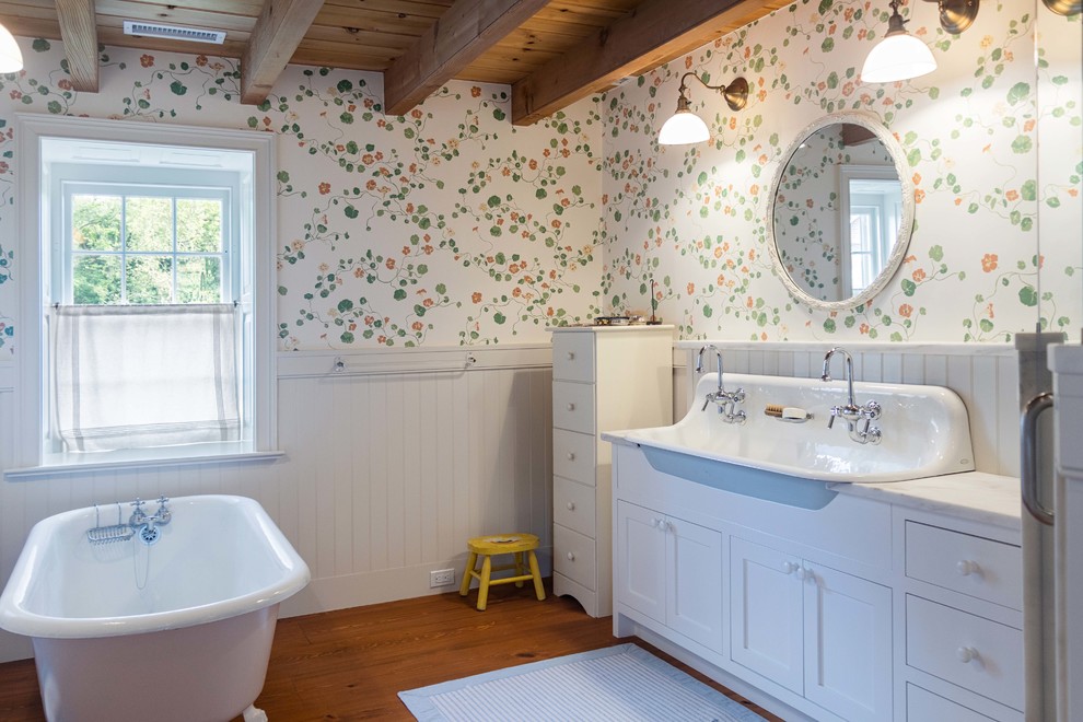 Inspiration for a country master bathroom in Philadelphia with shaker cabinets, white cabinets, a claw-foot tub, multi-coloured walls, medium hardwood floors, a trough sink, brown floor, a hinged shower door and white benchtops.
