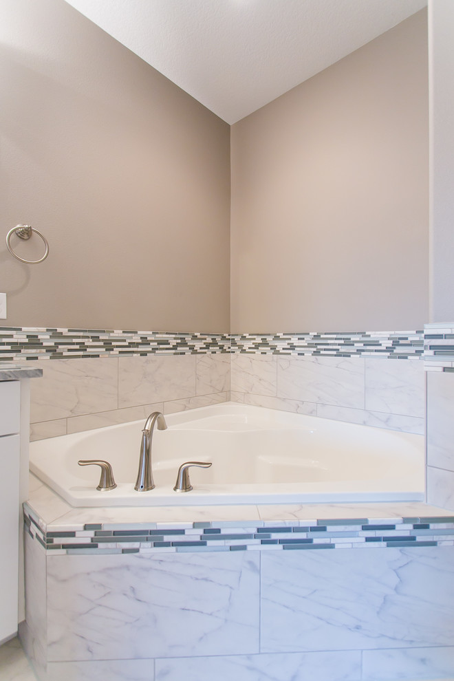 Corner bathtub - mid-sized transitional master multicolored tile and mosaic tile porcelain tile and white floor corner bathtub idea in Seattle with shaker cabinets, white cabinets, a two-piece toilet, gray walls, granite countertops, a hinged shower door and a drop-in sink