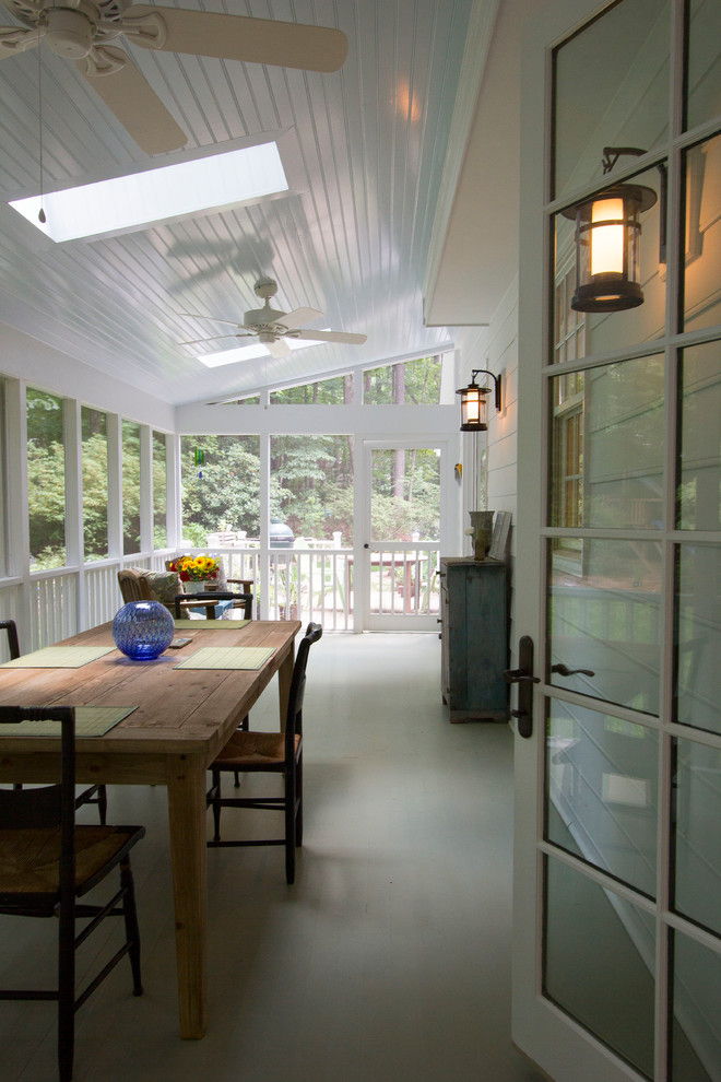 This is an example of a large transitional backyard screened-in verandah in Raleigh with decking and a roof extension.