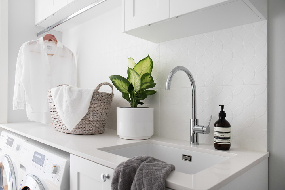 Design ideas for a mid-sized contemporary galley dedicated laundry room in Sydney with shaker cabinets, white cabinets, marble benchtops, grey walls, ceramic floors, a side-by-side washer and dryer, grey floor, white benchtop and an undermount sink.