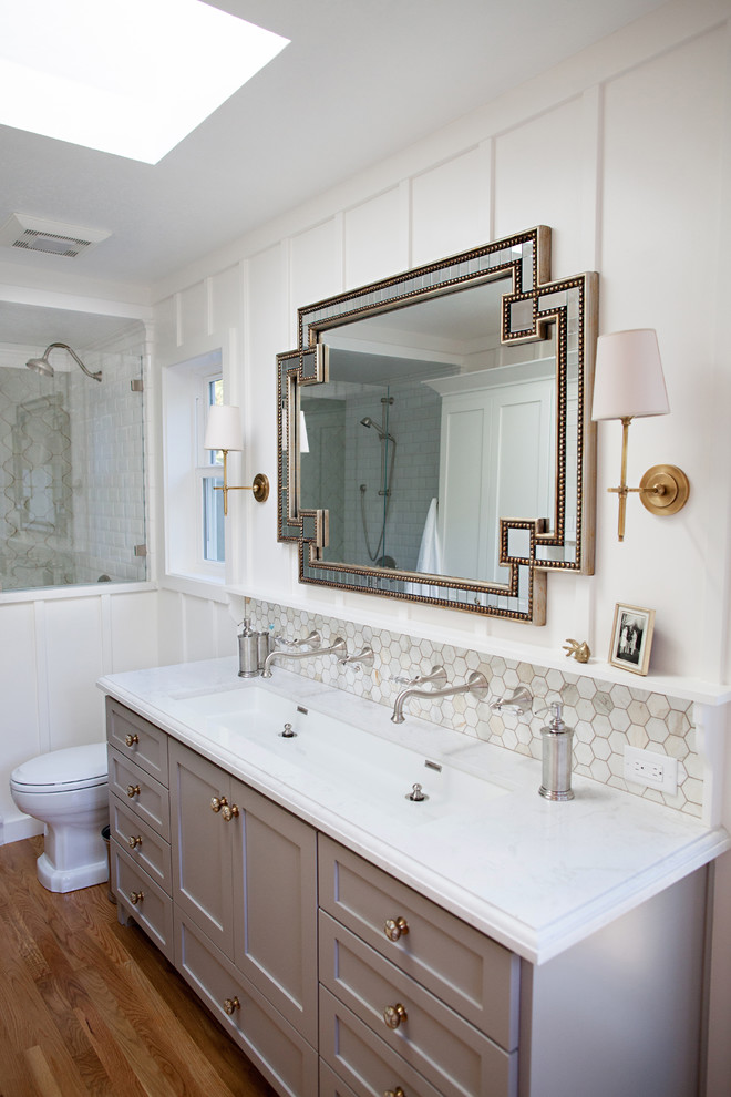 This is an example of a large transitional master bathroom in San Francisco with a trough sink, shaker cabinets, grey cabinets, engineered quartz benchtops, a double shower, a one-piece toilet, white tile, mosaic tile, white walls and medium hardwood floors.