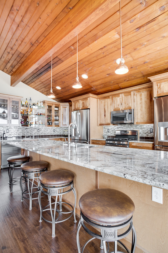 Inspiration for a large rustic kitchen remodel in DC Metro with an undermount sink, raised-panel cabinets, granite countertops, glass tile backsplash, stainless steel appliances and an island
