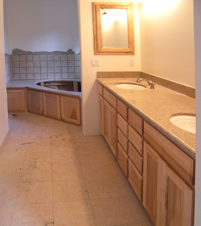 Example of a master white floor bathroom design with shaker cabinets, white walls and solid surface countertops