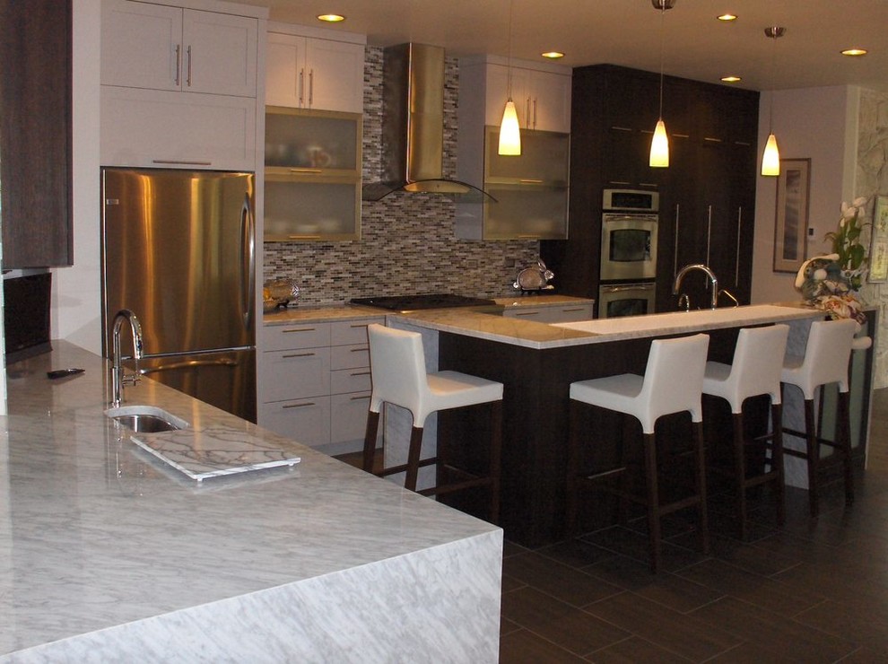 Inspiration for a mid-sized transitional l-shaped laminate floor and brown floor eat-in kitchen remodel in Boise with a drop-in sink, white cabinets, granite countertops, stainless steel appliances, an island, shaker cabinets, multicolored backsplash and glass sheet backsplash