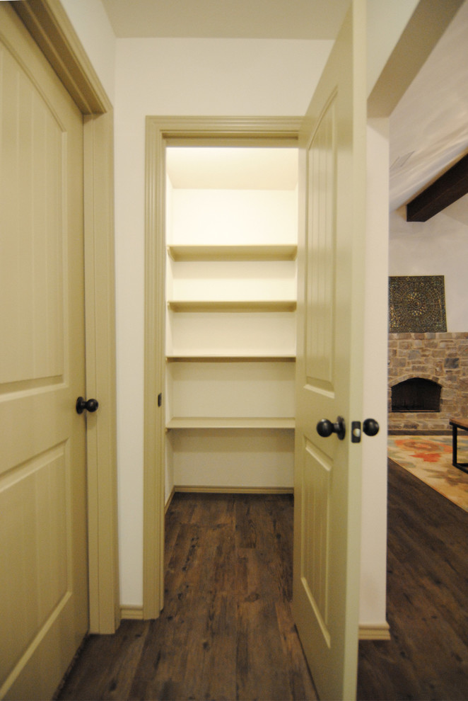 Design ideas for a mid-sized eclectic gender-neutral walk-in wardrobe in Austin with beige cabinets and vinyl floors.