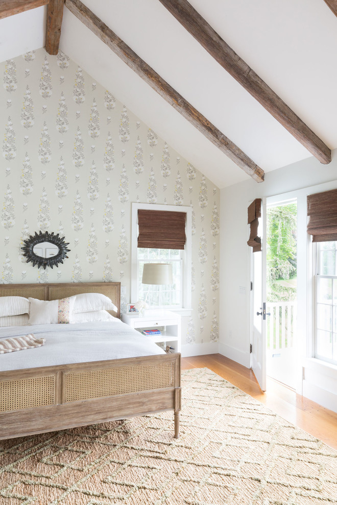 Cottage master medium tone wood floor and brown floor bedroom photo in New York with white walls