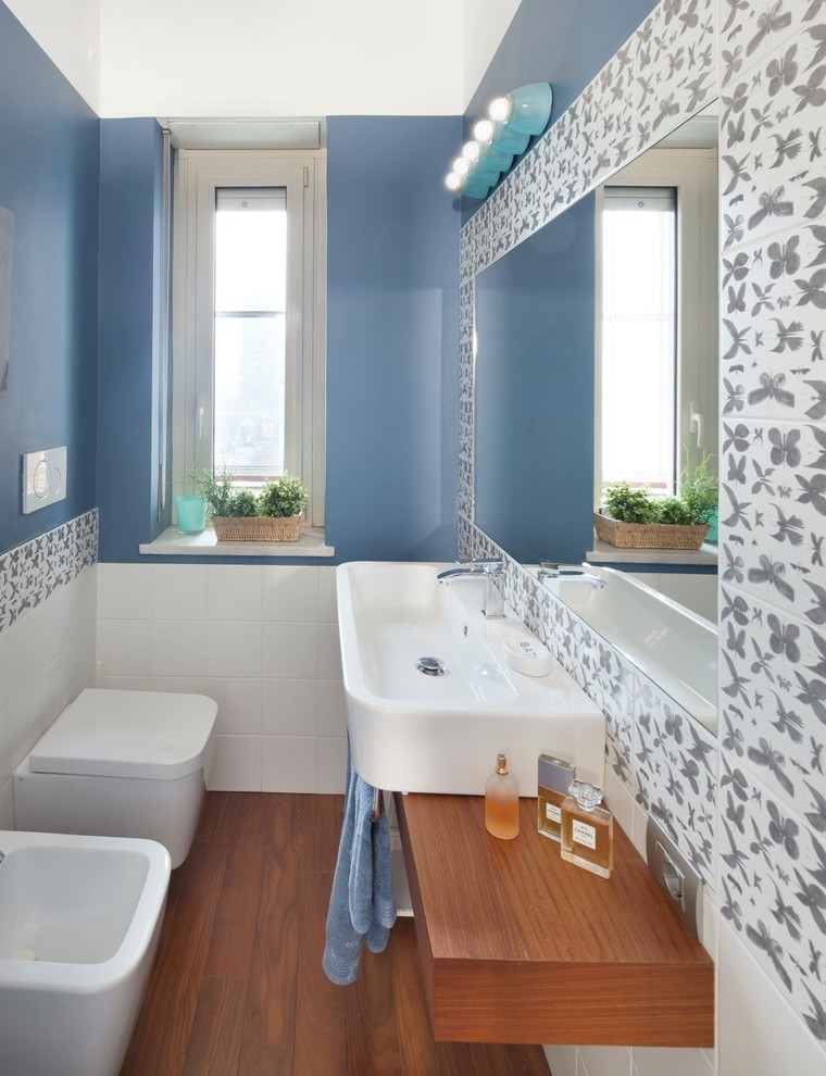 Photo of a mid-sized modern 3/4 bathroom in Milan with medium wood cabinets, a corner shower, a one-piece toilet, white tile, ceramic tile, white walls, dark hardwood floors, a vessel sink, wood benchtops and a sliding shower screen.