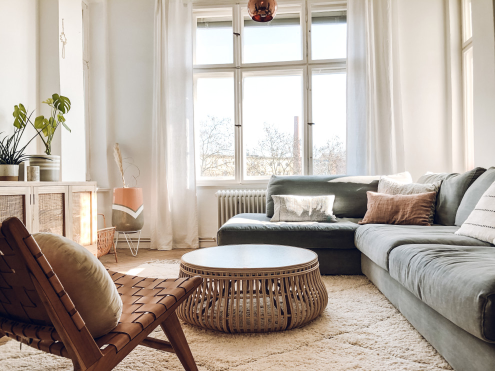 Offenes Skandinavisches Wohnzimmer mit hellem Holzboden und weißem Boden in Berlin