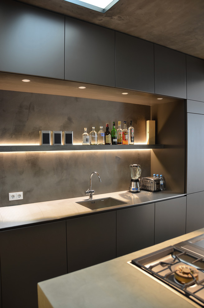Design ideas for a contemporary kitchen in Cologne with an undermount sink, flat-panel cabinets, grey cabinets, stainless steel benchtops, grey splashback and panelled appliances.