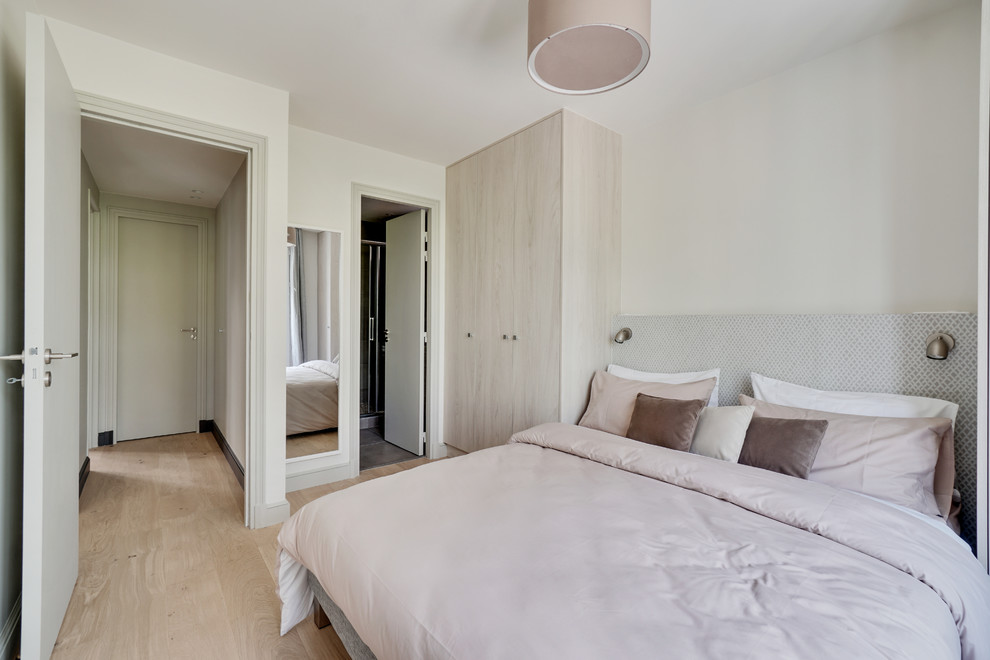 Photo of a contemporary guest bedroom in Paris with white walls, light hardwood floors and beige floor.