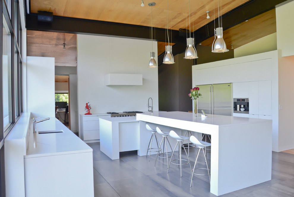 This is an example of a large contemporary u-shaped open plan kitchen in Kansas City with flat-panel cabinets, white cabinets, ceramic floors, multiple islands, an undermount sink, quartz benchtops and stainless steel appliances.