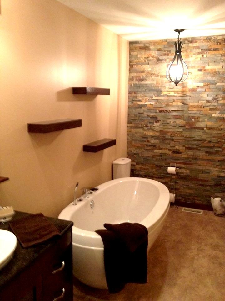 This is an example of a mid-sized modern 3/4 bathroom in Toronto with flat-panel cabinets, dark wood cabinets, a freestanding tub, multi-coloured tile, matchstick tile, beige walls, concrete floors, a vessel sink, granite benchtops and beige floor.