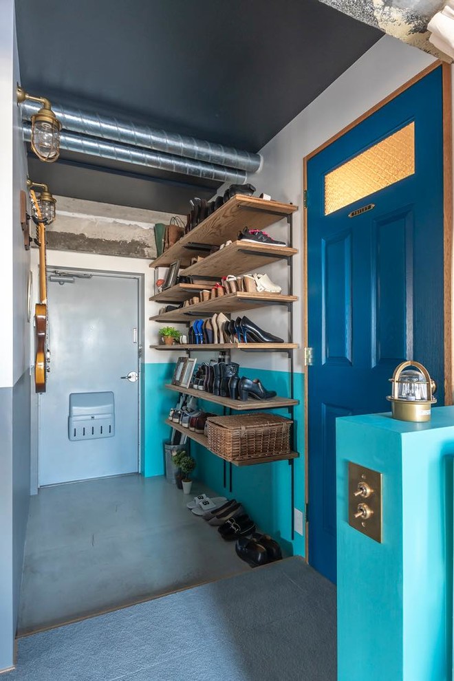 This is an example of an industrial mudroom in Tokyo with white walls and grey floor.