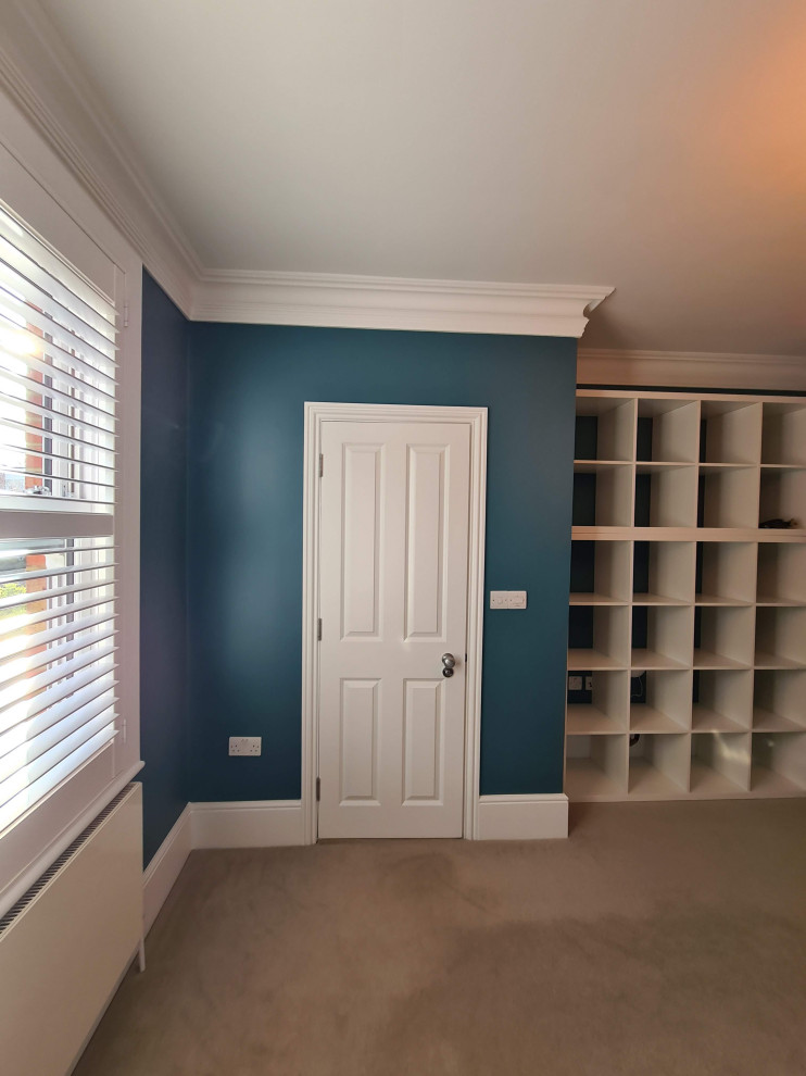 Inspiration för ett mellanstort funkis hemmastudio, med blå väggar, heltäckningsmatta, ett fristående skrivbord och beiget golv